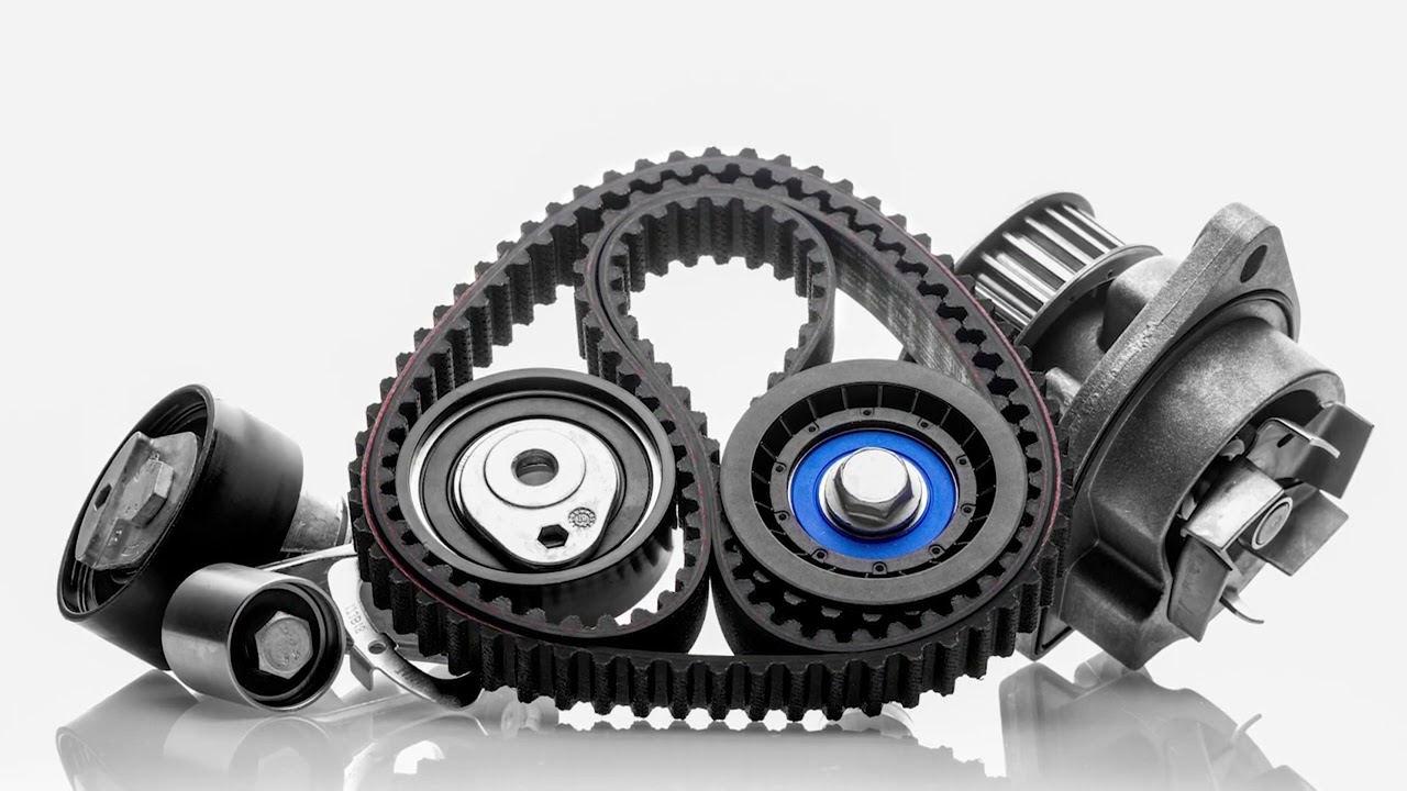 Close-up of a worn timing belt and pulleys removed from a car engine bay