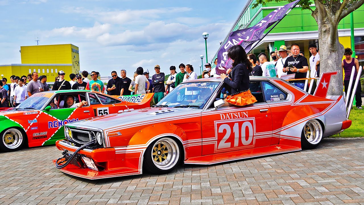 Modified Japanese kaido racer style car with oversized fender flares and takeyari exhaust pipes