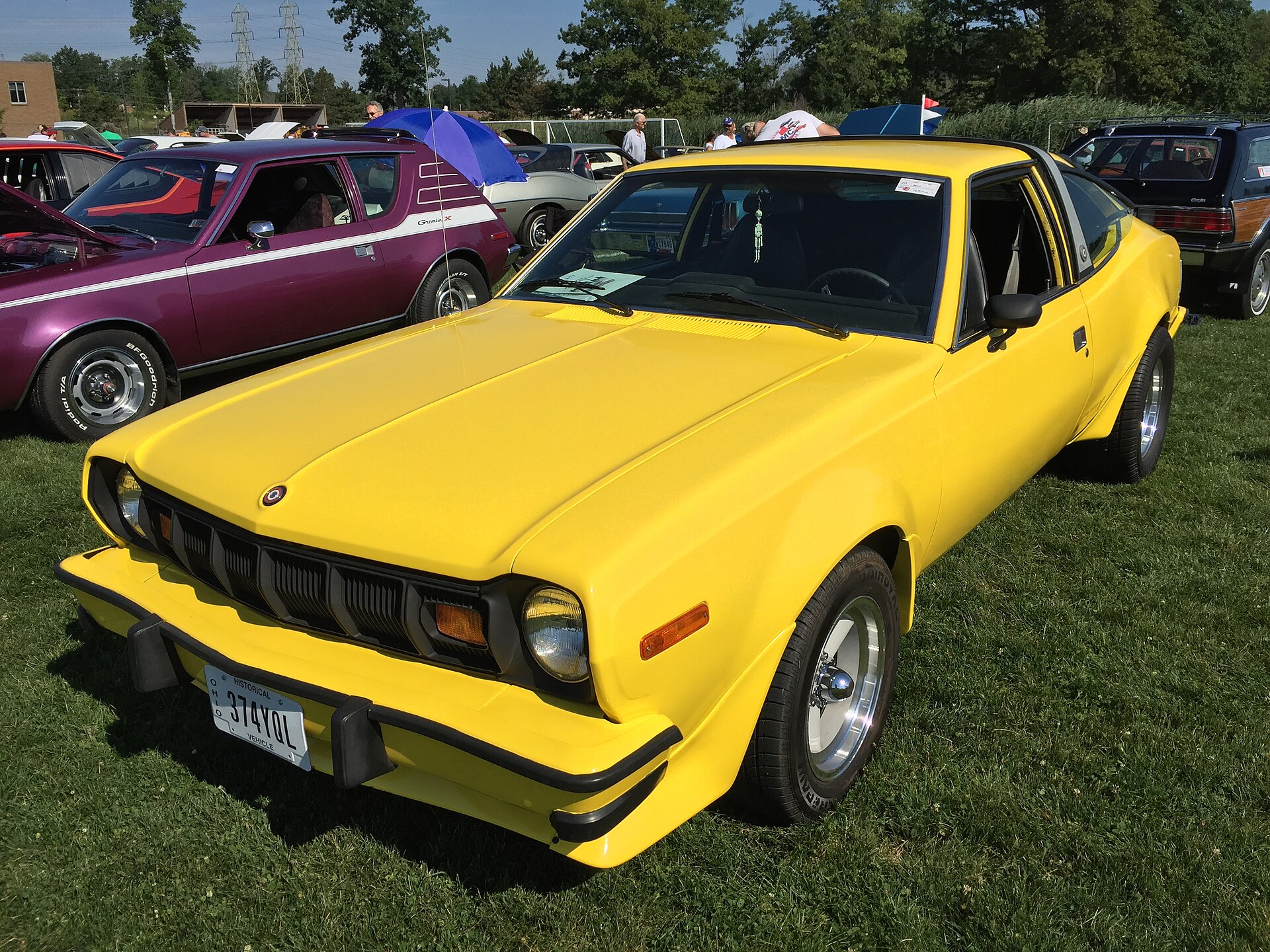 Modified car with aftermarket wheels and exhaust parked at a car meet, representing the insurance challenges of owning a modified vehicle