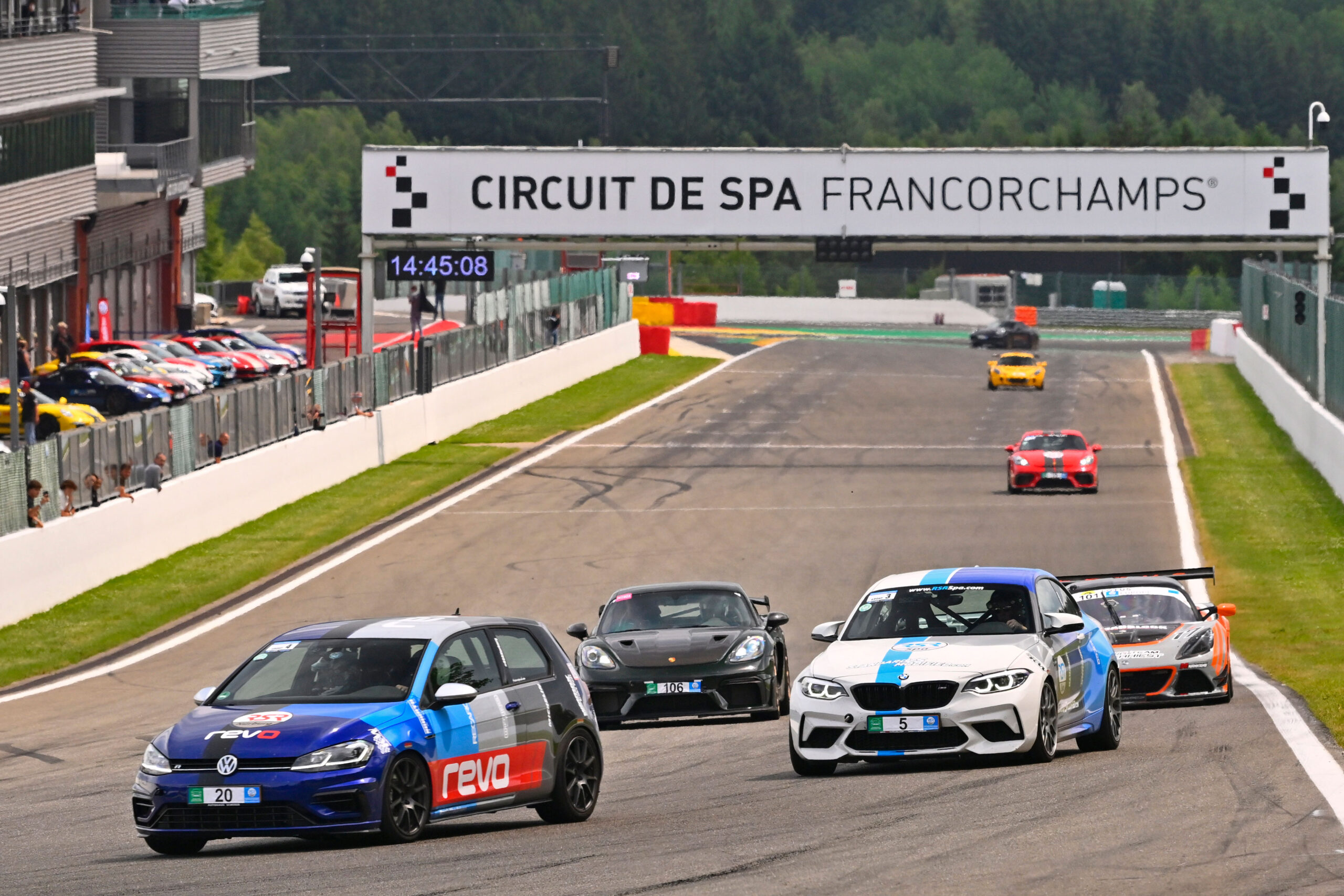 Modified sports car cornering hard on a race track during an open track day event